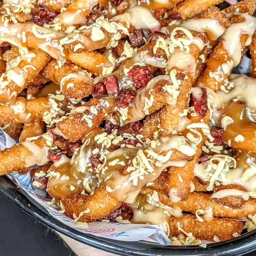 Milky Lane Loaded Donut Churro Fries in a bowl - cinnamon sugar churro fries under Cherry Ripe, Milky Bar, salted caramel and strawberry jam custard